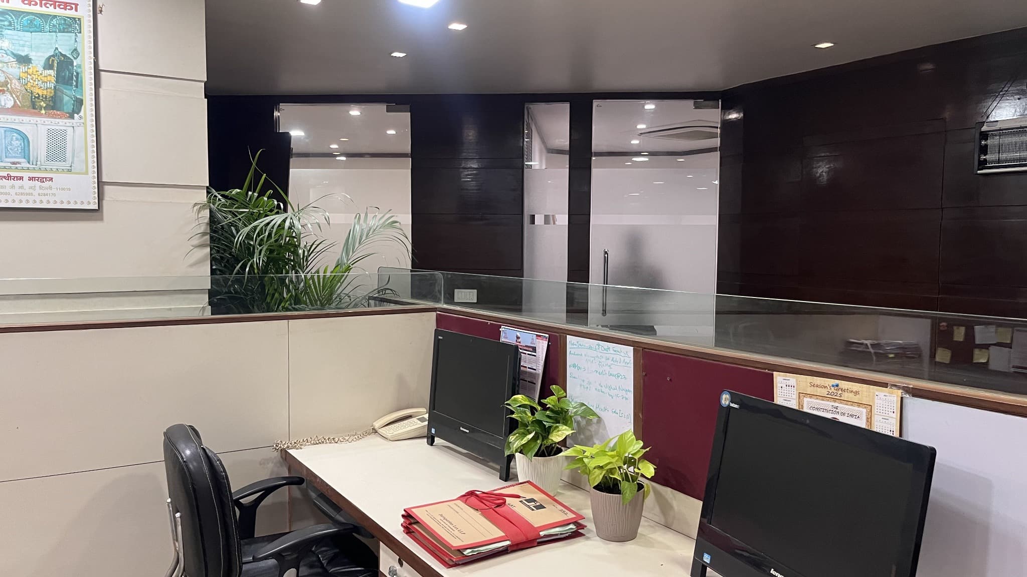 Office cubicle with monitors and plants